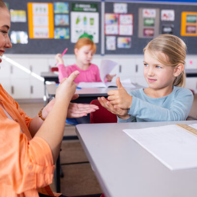 Educator speaking to a hard of hearing student with ASL